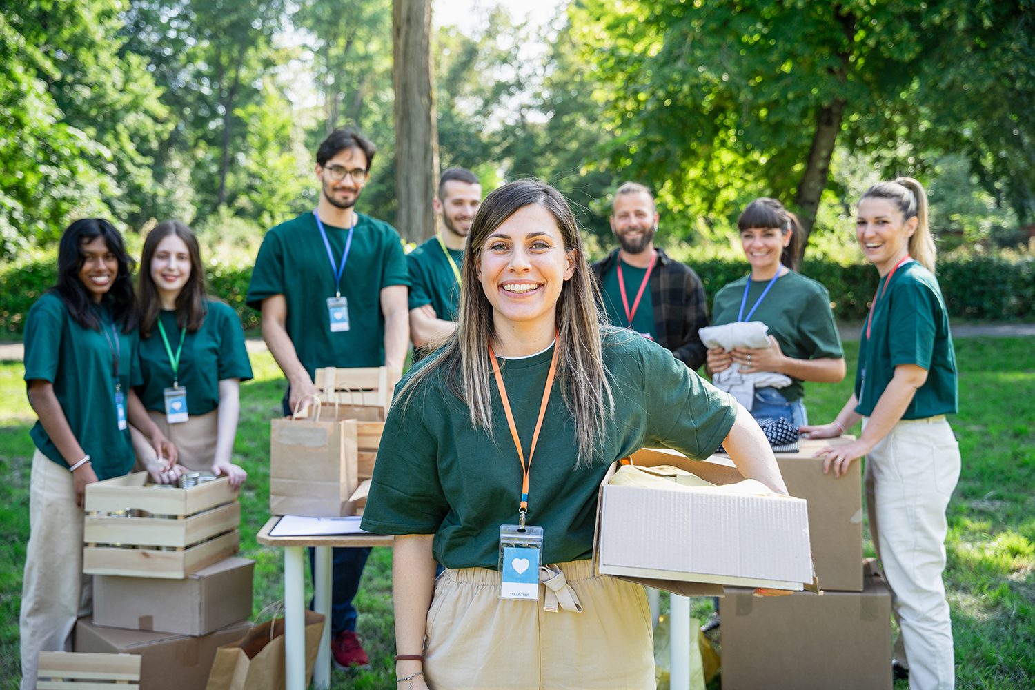 A group of people doing community work in green shirts, smiling at the camera.